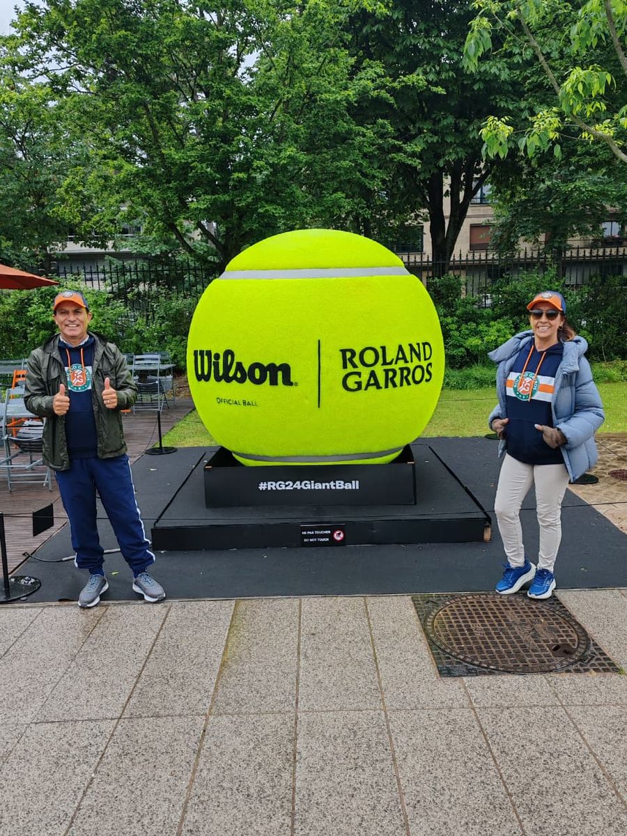 Dos del grupo junto a la pelota gigante de Roland Garros