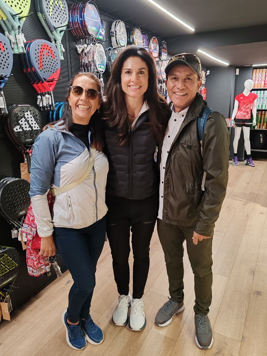 Tres del grupo entre las raquetas de la tienda